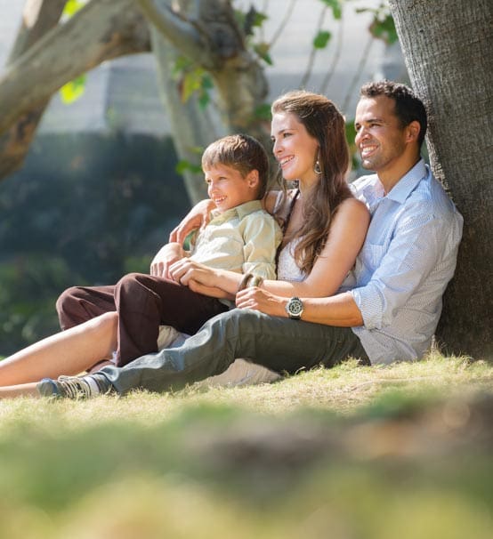 Family Sitting By Tree